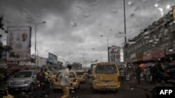 Un homme se précipite pour traverser la rue sous une pluie battante à Kinshasa, le 17 décembre 2018.