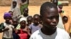 FILE - Anas Mustapha, 14 years old, at right, who was tested with the meningitis epidemic experimental drug, looks on as he stands with some children in Kano, Nigeria, September 7, 2012.