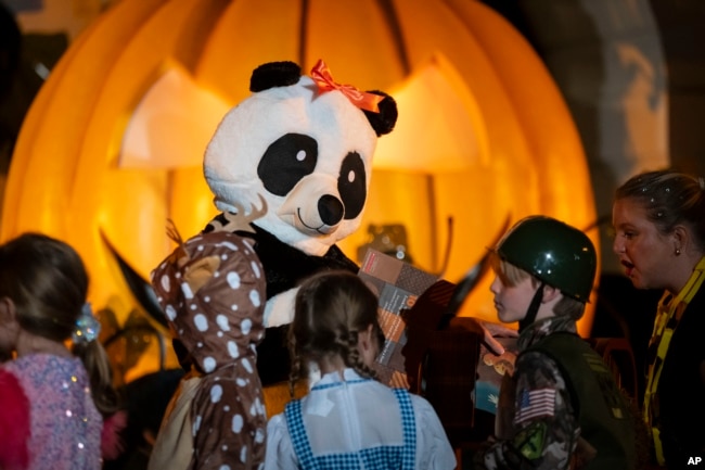 While wearing a panda costume, first lady Jill Biden greets children during a Halloween celebration at the White House in Washington, Oct. 30, 2024.