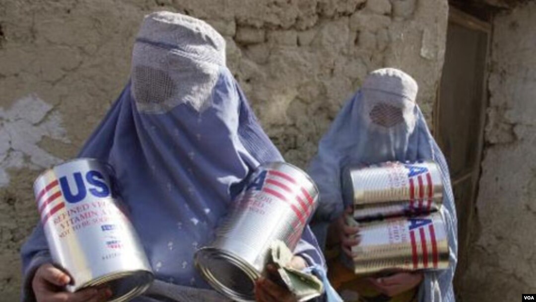 Dua janda Afghanistan membawa minyak goreng kalengan yang dibagikan oleh WFP di Kabul, Afghanistan (foto: dok.).