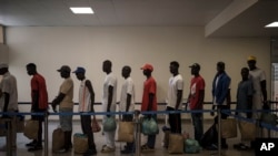 Los sobrevivientes de la piragua senegalesa que fue encontrada a la deriva hacen fila en el aeropuerto antes de abordar un vuelo para ser repatriados, en la isla de Sal, Cabo Verde, el lunes 21 de agosto de 2023.