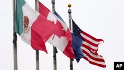 Bendera Meksiko, Kanada, dan Amerika Serikat berkibar di dekat Jembatan Ambassador di Detroit pada Senin, 3 Februari 2025. (Foto: AP)