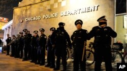 FILE - Chicago police officers line up outside the District 1 central headquarters during a protest of a police shooting in Chicago, Nov. 24, 2015.