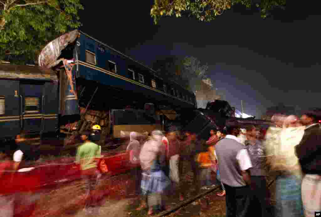 Rescue workers and locals gather in front of a wrecked train in Narsingdi December 8, 2010. At least seven people were killed and 50 were injured in a head-on train collision in Bangladesh on Wednesday. (Andrew Biraj/Reuters)