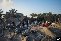 Palestinians look at the destruction after an Israeli airstrike on a crowded tent camp housing Palestinians displaced by the war in Muwasi, Gaza Strip, Sept. 10, 2024.