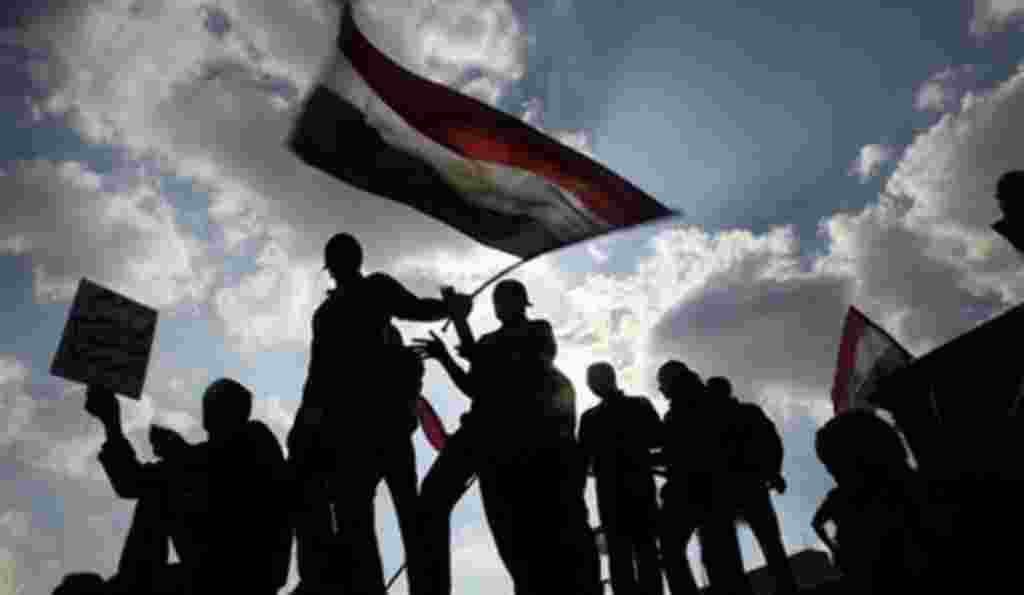 Anti-government protesters hold an Egyptian flag during demonstrations in Tahrir Square in downtown Cairo, Egypt Tuesday, Feb. 8, 2011.