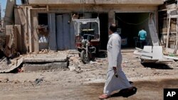 Civilians inspect aftermath of car bomb attack in Husseiniyah area of northeastern Baghdad, Iraq, April 25, 2013.