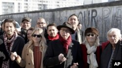 یک بخش کوتاه از دیوار برلین باقیمانده که گاهی برخی مثل این گروه از هنرمندان در حاشیه جشنواره فیلم برلین در کنار آن عکس می گیرند.