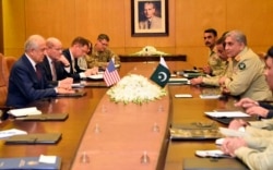 FILE - In this photo released by Inter Services Public Relations of Pakistan's military, U.S. envoy Zalmay Khalilzad, left, talks with Pakistani Army Chief Gen. Qamar Javed Bajwa, second-right, during a meeting in Rawalpindi, Pakistan, Jan. 17, 2019.