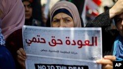 Beirut: A Palestinian woman holds a placard with Arabic that reads: "The return is a definite right" during a demonstration against a U.S.-sponsored Middle East economic workshop in Bahrain, June 25, 2019. 