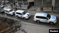 An aid convoy of Syrian Arab Red Crescent and UN drives through the rebel held besieged city of Douma, Syria, Feb. 23, 2016. 