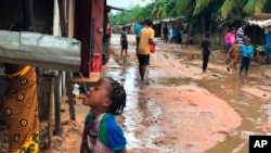 ARCHIVES - Une fillette boit l'eau qui coule d'une gouttière après des inondations dues à de fortes pluies à Pemba, au Mozambique, le 28 avril 2019.