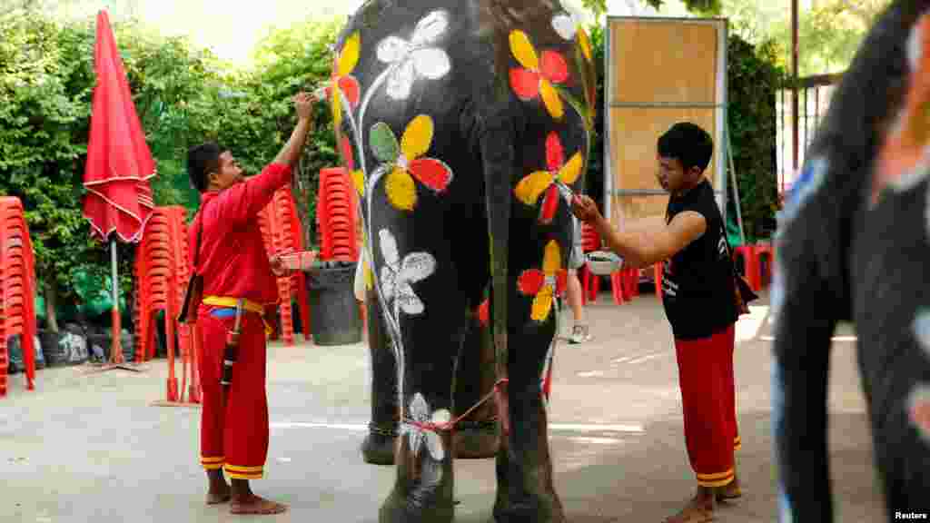 Mahouts peind un éléphant avant la célébration de la fête de l'eau de Songkran dans la province d'Ayutthaya, le 11 avril 2016.