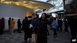 FILE - Shoppers visit a popular mall in Beijing, Dec. 15, 2024. 