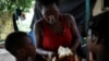 An African migrant spreads peanut butter on bread for children in Tapachula, Mexico, May 15, 2019. 