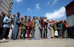 People stand in line to cast their vote during the referendum on draft constitutional amendments, at a polling station in Cairo, Egypt April 20, 2019.