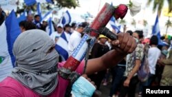 A protester poses with his homemade mortar during a protest against President Daniel Ortega's government in Managua, Nicaragua, May 30, 2018. 