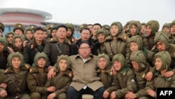This undated picture released from North Korea's official Korean Central News Agency, Nov. 18, 2019, shows North Korean leader Kim Jong Un posing with members of the Air and Anti-Aircraft Force of the Korean People's Army.