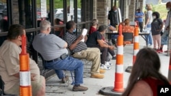 FILE - Job seekers exercise social distancing as they wait to be called into the Heartland Workforce Solutions office in Omaha, Nebraska, July 15, 2020.