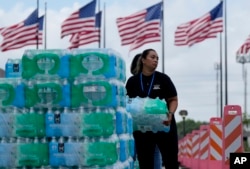 FILE - Staf di Gereja Lakewood membagikan air dan mengoperasikan stasiun pendingin di Houston, 9 Juli 2024. (Eric Gay/AP)