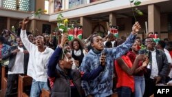 Youth attending a special dedication service at the Holy Family Basilica hold roses in honour of lives lost during recent protests against government proposed tax hikes on "saba-saba" day, a local euphemism for July 7, a day symbolising the struggle again