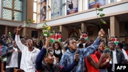 Youth attending a special dedication service at the Holy Family Basilica hold roses in honor of lives lost during recent protests in Nairobi on July 7, 2024.