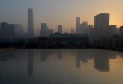 FILE - Air pollution hangs over the skyline as the sun rises over Beijing’s central business district, Jan. 14, 2013.