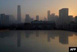 FILE - Air pollution hangs over the skyline as the sun rises over Beijing’s central business district, Jan. 14, 2013.