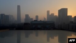 Air pollution hangs over the skyline as the sun rises over Beijing’s central business district. Dense smog shrouded the city with pollution at hazardous levels for a fourth day and residents were advised to stay indoors, January 14, 2013.