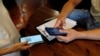 FILE - A woman's Green Pass (health pass) is checked before entering a pizzeria as Italy brings in tougher restrictions where a proof of immunity will be required to access an array of services and leisure activities, in Rome, Italy, Aug. 6, 2021.