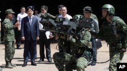 FILE - Taiwanese President Lai Ching-te, second from left, listens to a briefing during a missile launcher demonstration at a military base on Penghu Island on Sept. 6, 2024. China, which considers Lai a "separatist," is expected to closely monitor his Double Ten Day remarks