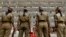 FILE - Indian policemen in ceremonial uniforms stand at attention in front of the civil secretariat complex on the first day of the Darbar Move in Srinagar, May 9, 2011. 
