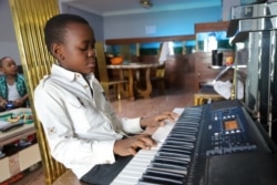 A boy plays strikes a chord on his keyboard inside his apartment during the spread of the coronavirus disease (COVID-19), in Kinshasa, Democratic Republic of Congo April 18, 2020. (REUTERS PHOTO/Kenny Katombe)