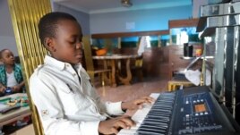 A boy plays strikes a chord on his keyboard inside his apartment during the spread of the coronavirus disease (COVID-19), in Kinshasa, Democratic Republic of Congo April 18, 2020. (REUTERS PHOTO/Kenny Katombe)