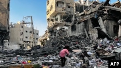 Une jeune fille palestinienne inspecte les décombres d'un bâtiment après une frappe israélienne à Beit Lahia, dans le nord de la bande de Gaza, le 29 octobre 2024.