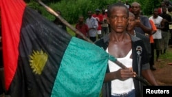 FILE - A man carries the Biafran flag during a parade in Ekwe village, near Enugu in southeastern Nigeria, May 27, 2008. 