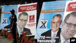 A private security guard stands in front of campaign signs of Otto Perez Molina, presidential candidate of the Patriotic Party, center, and Manuel Baldizon, presidential candidate of the Democratic Freedom Revival party in Guatemala City, November 5, 2011