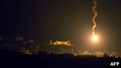 A picture taken from the southern Israeli border with the Gaza Strip shows Israeli flares illuminating the Palestinian coastal enclave, July 7, 2014.