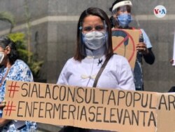 Una trabajadora del sector salud en Venezuela sostiene un cartel que muestra su acuerdo con la consulta popular en ese país. Foto Álvaro Algarra/VOA.