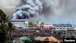 Black smoke comes from a burning building in a commercial area of Osmena street in Marawi city, Philippines June 14, 2017. 