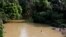 FILE - A boy swims in a river polluted by gold mining waste in Nsuaem district, western Ghana, Nov. 23, 2018. 