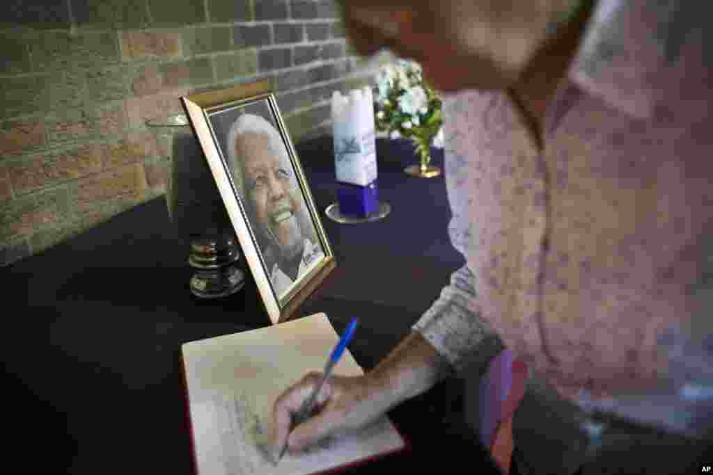 A mourner signs the book of condolences at the iconic Regina Mundi church, which became one of the focal points of the anti-apartheid struggle, in Soweto, Johannesburg, South Africa Saturday, Dec. 7, 2013