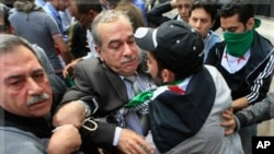 Syrian protesters prevent Abdul-Aziz al-Khair, a member of the Syrian National Coordination Committee, second from left, and other opposition leaders from entering the Arab League headquarters where they were to hold talks with the organization's chief on