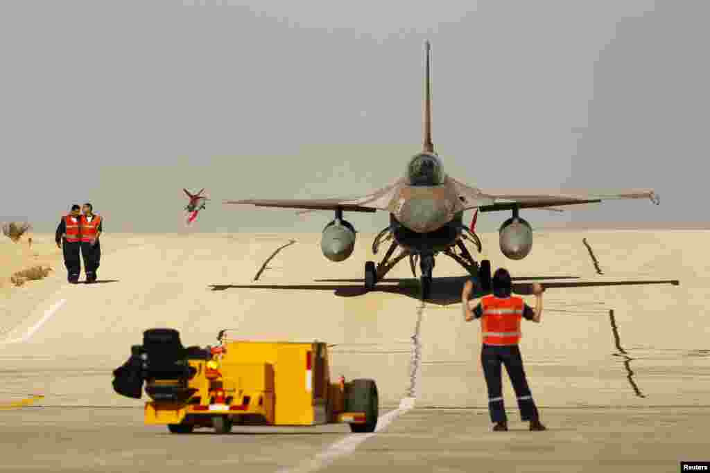 A ground crew member directs an Israeli F-16 fighter jet after it landed at Ovda airbase, some 40 km (25 miles) north of Eilat, during the Blue Flag drill. The Blue Flag drill is a two-week multilateral air force drill with air forces of Israel, the United States, Greece and Italy.