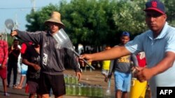 Hombres ofrecen gasolina a la venta en las calles de Maracaibo, estado Zulia, Venezuela, el 25 de agosto de 2020, en medio de la pandemia del coronavirus COVID-19.