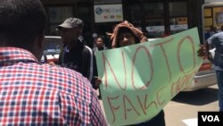 A Zimbabwean protests against the newly introduced bond notes, which he calls “fake money,” in Harare, Nov. 30, 2016. President Robert Mugabe introduced the new currency to ease the country’s almost year-long cash shortage problem. (S. Mhofu/VOA)