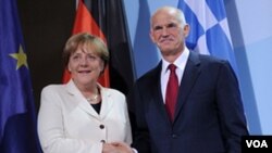 Kanselir Jerman Angela Merkel dan PM Yunani Georgios Papandreou berjabat tangan sebelum melakukan pembicaraan dan makan malam bersama di Berlin, Jerman (27/9).