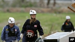 A search and rescue team looks for victims at a devastated apartment complex in Joplin, Missouri, May 26, 2011.