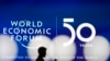 A man silhouettes in front of the logo of the World Economic Forum in Davos, Switzerland, Sunday, Jan. 19, 2020. 