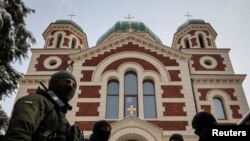 ARCHIVO - Fuerzas de seguridad ucranianas montan guardia frente a la Catedral de la Iglesia Ortodoxa en Ucrania, leal a Moscú, en la localidad de Lviv, en diciembre de 2022.